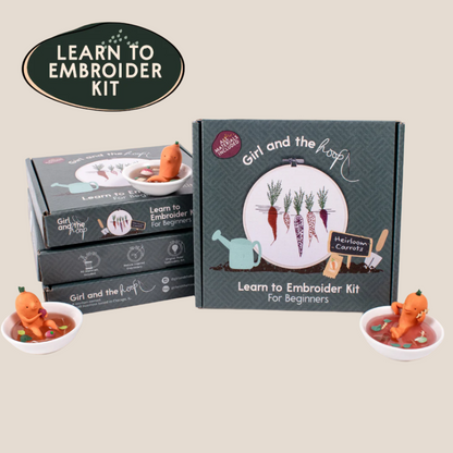 The image shows a carrot embroidery kit for beginners, including a fabric piece with a carrot design, an embroidery hoop, thread, needle, and a box with the product title 'Learn to Embroider Kit for Beginners'.
